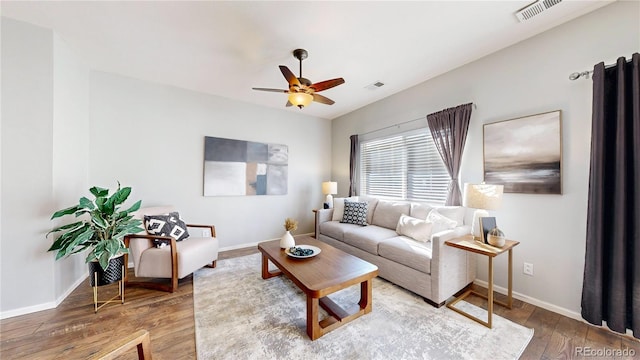 living room with ceiling fan, hardwood / wood-style flooring, visible vents, and baseboards