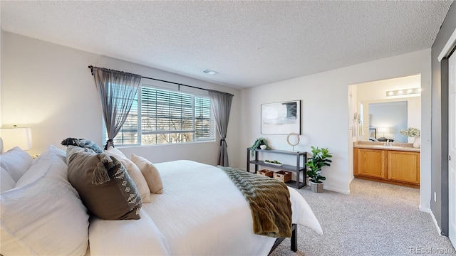 bedroom featuring light carpet, visible vents, a textured ceiling, and ensuite bathroom