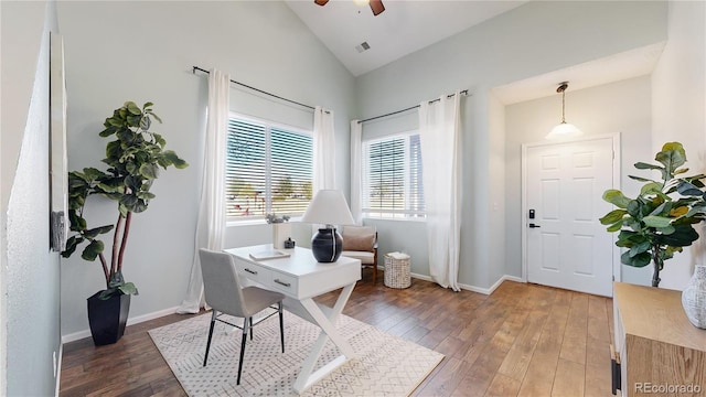 home office featuring hardwood / wood-style flooring, visible vents, baseboards, and vaulted ceiling