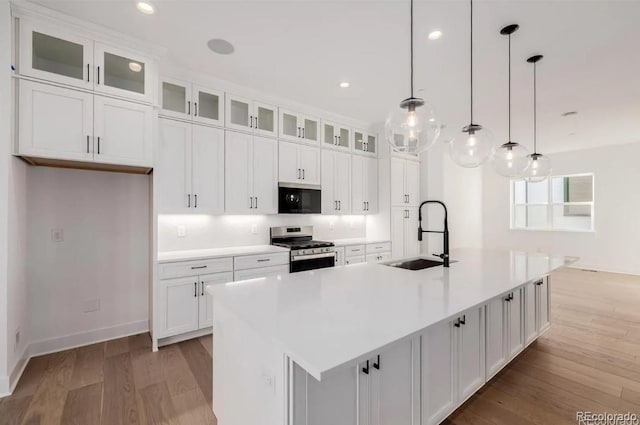 2361 Junegrass Ln, Superior, CO 80027 - kitchen featuring a sink, stainless steel range with gas stovetop, light wood-style floors, white cabinets, and recessed lighting