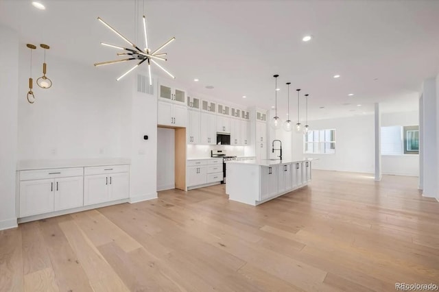 2361 Junegrass Ln, Superior, CO 80027 - kitchen featuring stainless steel appliances, white cabinets, light wood-style floors, glass insert cabinets, and a sink
