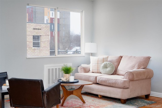 living area with visible vents, baseboards, and wood finished floors