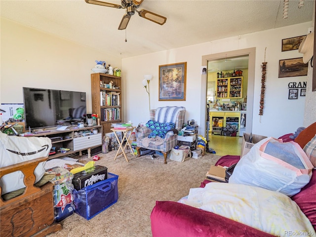 living room featuring carpet floors, ceiling fan, and a textured ceiling