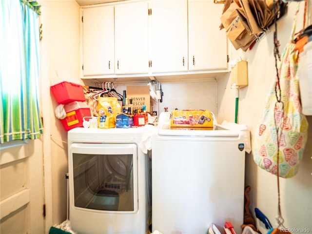 clothes washing area with cabinet space and separate washer and dryer