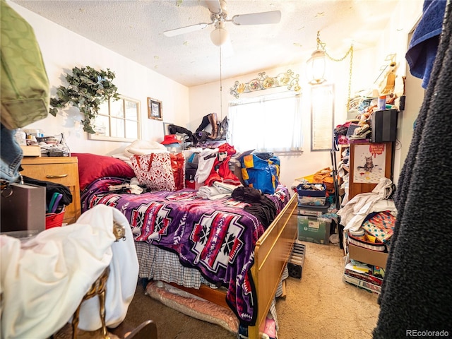 carpeted bedroom with a textured ceiling, multiple windows, and a ceiling fan