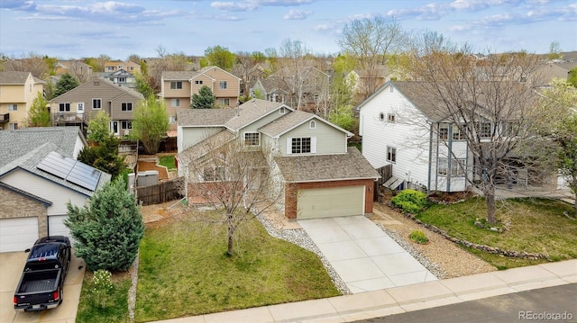 traditional-style home with roof with shingles, a residential view, brick siding, concrete driveway, and an attached garage