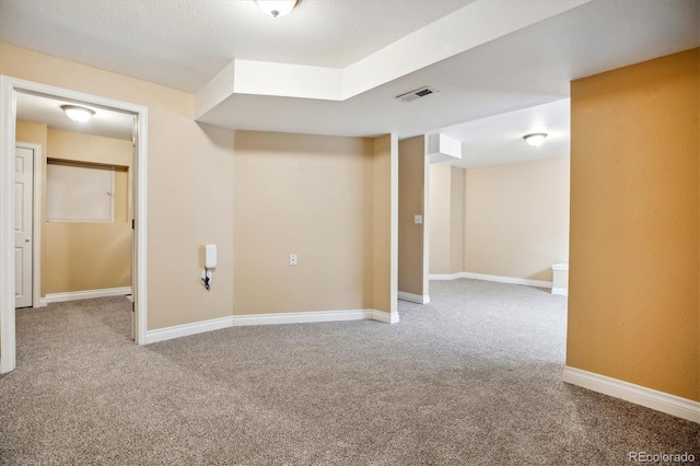 finished basement with baseboards, carpet flooring, and visible vents