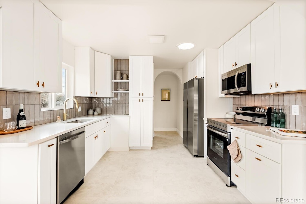 kitchen featuring white cabinetry, sink, tasteful backsplash, and appliances with stainless steel finishes