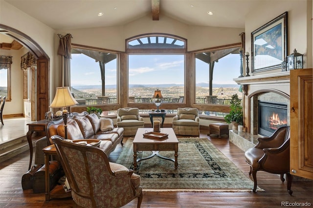 interior space with a mountain view, vaulted ceiling with beams, dark hardwood / wood-style flooring, and plenty of natural light