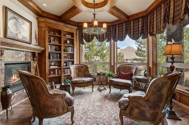 living area featuring hardwood / wood-style flooring, a high end fireplace, beam ceiling, and built in shelves