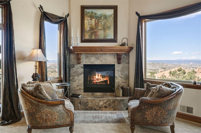 living area featuring carpet flooring, a fireplace, and plenty of natural light