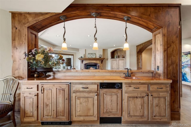 kitchen with butcher block counters, sink, and decorative light fixtures