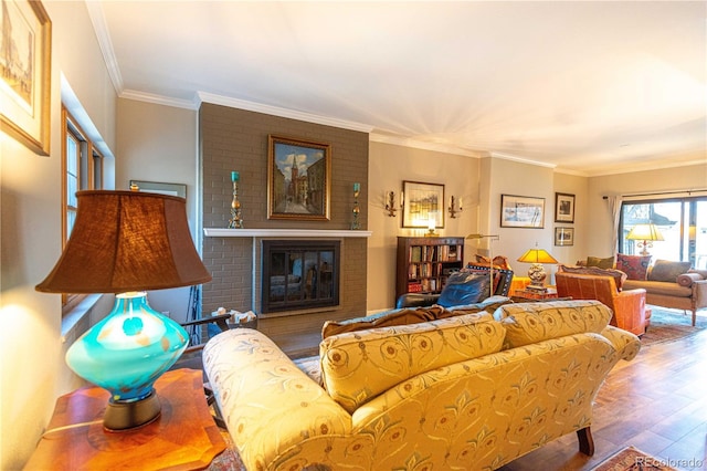 living area featuring a fireplace, wood finished floors, and crown molding