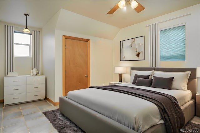 bedroom featuring ceiling fan, lofted ceiling, and light tile patterned floors