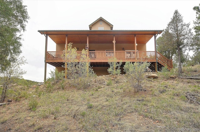 rear view of house featuring a wooden deck