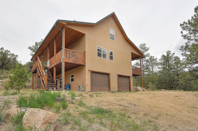 rear view of property with a garage and a wooden deck