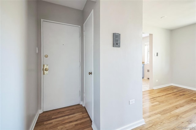 corridor featuring wood finished floors and baseboards