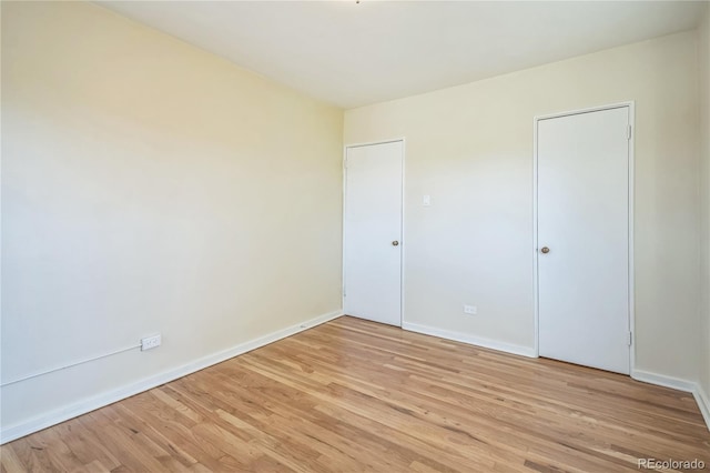 unfurnished bedroom featuring light wood-type flooring and baseboards