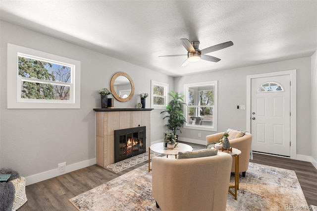 1130 E Yampa St, Colorado Springs, CO 80903 - living room featuring wood finished floors, a ceiling fan, baseboards, a fireplace, and a textured ceiling
