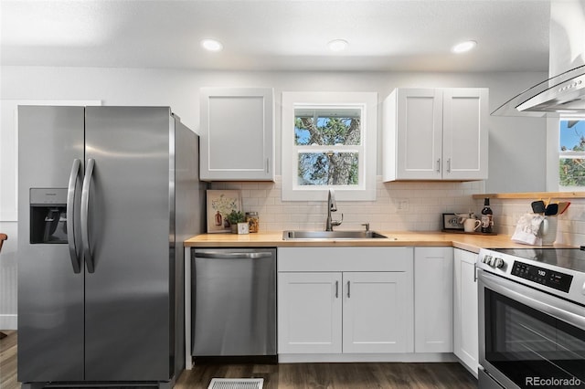 1130 E Yampa St, Colorado Springs, CO 80903 - kitchen with stainless steel appliances, a sink, wall chimney exhaust hood, butcher block countertops, and tasteful backsplash