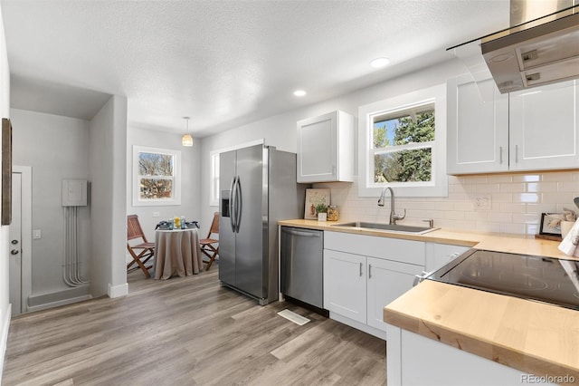 1130 E Yampa St, Colorado Springs, CO 80903 - kitchen with a sink, decorative backsplash, light wood finished floors, exhaust hood, and appliances with stainless steel finishes