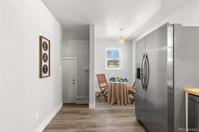 1130 E Yampa St, Colorado Springs, CO 80903 - kitchen with decorative light fixtures, baseboards, stainless steel appliances, and light wood-style flooring