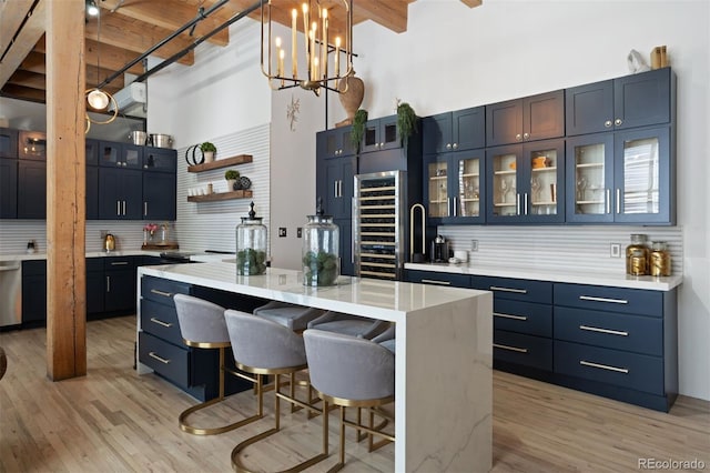 kitchen with a towering ceiling, decorative backsplash, a kitchen island, and blue cabinets