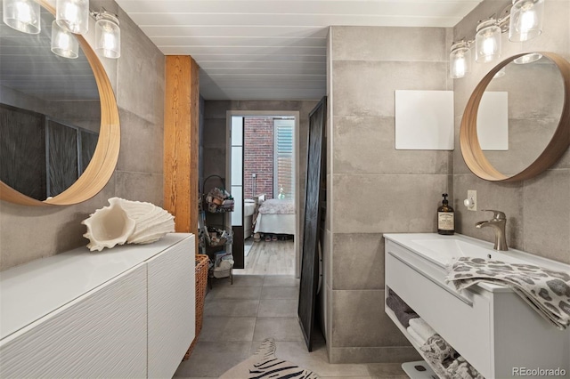 bathroom with vanity and tile walls