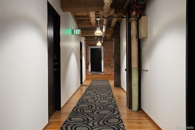 hall featuring beamed ceiling and light hardwood / wood-style flooring