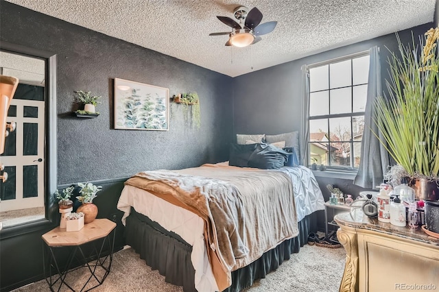 carpeted bedroom featuring ceiling fan and a textured ceiling