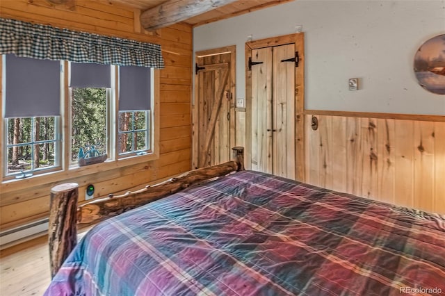 987 Boreas Cir, Jefferson, CO 80456 - bedroom with wood walls, beamed ceiling, wood finished floors, wainscoting, and a baseboard heating unit