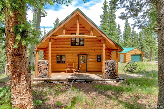 987 Boreas Cir, Jefferson, CO 80456 - rear view of house featuring log exterior, a detached garage, an outdoor structure, and a porch