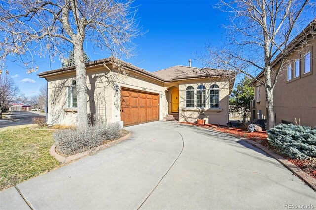 view of front of house with stucco siding, driveway, and an attached garage