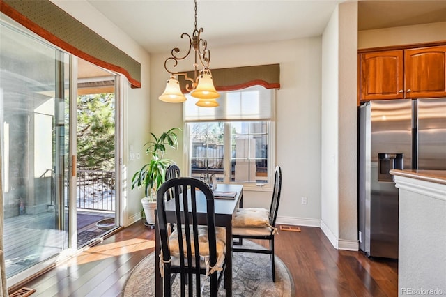 dining space with dark wood finished floors and baseboards