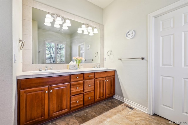 full bath with double vanity and baseboards