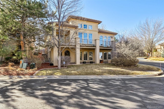 rear view of property featuring a balcony and stucco siding
