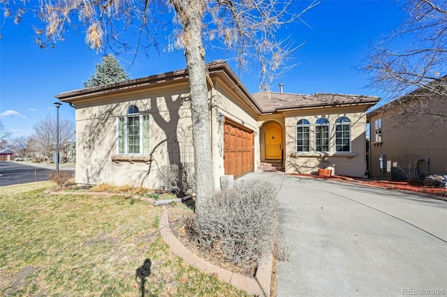 view of front of home with a garage, driveway, stucco siding, and a front lawn