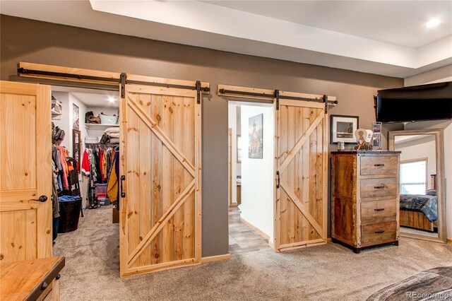 42919 Vista Rdg, Parker, CO 80138 - bedroom with a barn door, light carpet, a spacious closet, and a closet