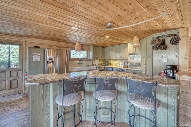 kitchen with light stone counters, wooden walls, a healthy amount of sunlight, and light wood-type flooring