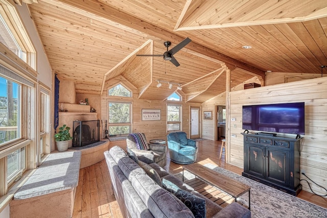 living room with wood-type flooring, vaulted ceiling with beams, wooden walls, and wood ceiling