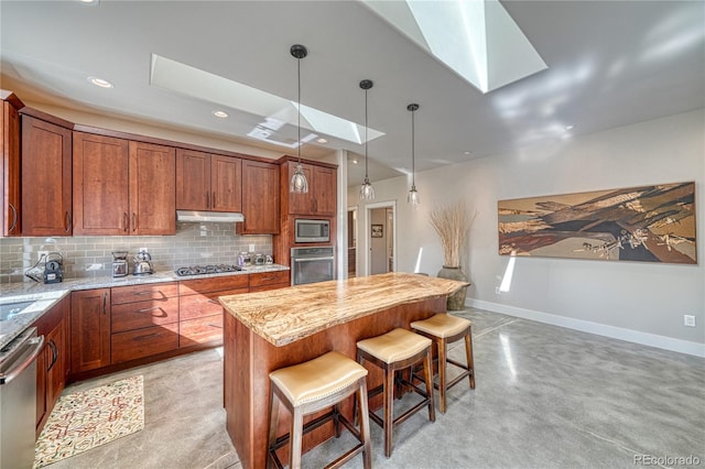 322 W Park Ave, Salida, CO 81201 - kitchen with a skylight, stainless steel appliances, under cabinet range hood, brown cabinets, and baseboards