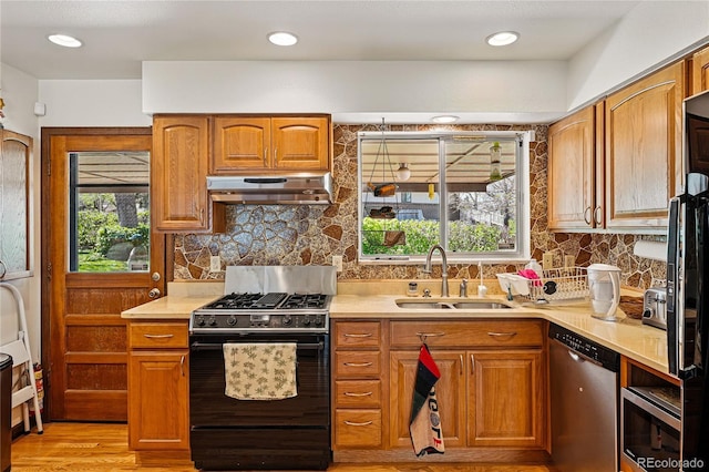 7590 E Easter Pl, Centennial, CO 80112 - kitchen featuring black gas stove, dishwasher, under cabinet range hood, a sink, and light countertops