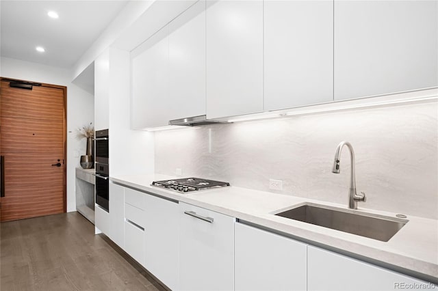 kitchen with white cabinets, appliances with stainless steel finishes, light countertops, and a sink