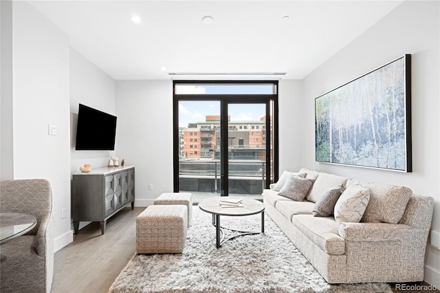 living room with expansive windows, recessed lighting, light wood-type flooring, and baseboards