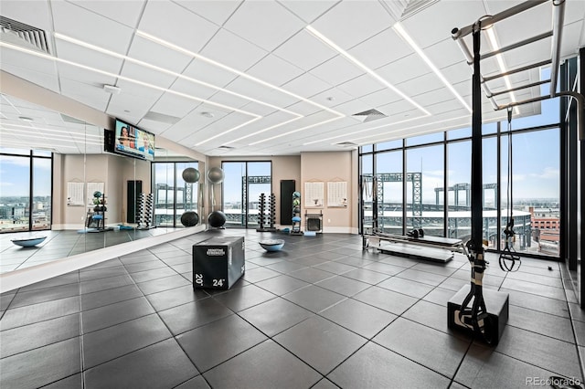 exercise room featuring baseboards, visible vents, and floor to ceiling windows