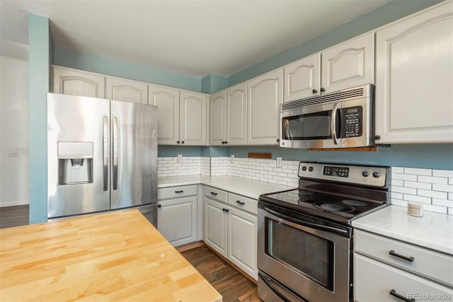 20445 Mitchell Pl, Denver, CO 80249 - kitchen with appliances with stainless steel finishes, wood counters, dark wood-type flooring, and decorative backsplash