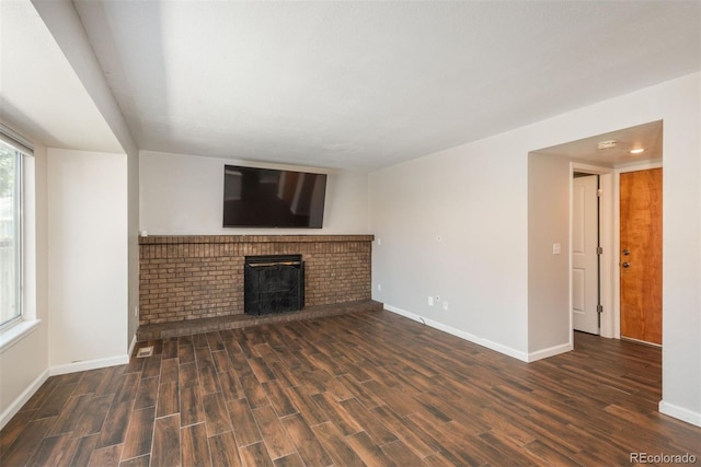 20445 Mitchell Pl, Denver, CO 80249 - unfurnished living room with wood finished floors and a brick fireplace