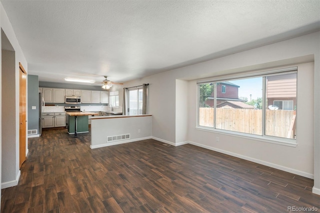 20445 Mitchell Pl, Denver, CO 80249 - kitchen with stainless steel appliances, dark wood-style flooring, ceiling fan, a peninsula, and open floor plan