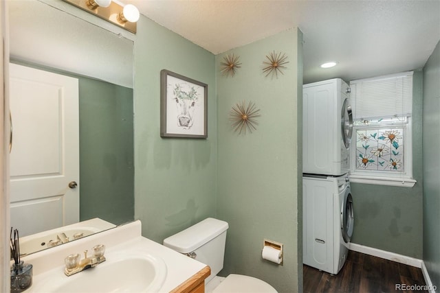 20445 Mitchell Pl, Denver, CO 80249 - half bath with stacked washing machine and dryer, wood finished floors, vanity, and recessed lighting