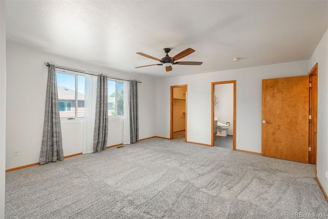 20445 Mitchell Pl, Denver, CO 80249 - unfurnished bedroom with carpet floors, a walk in closet, ceiling fan, and ensuite bath